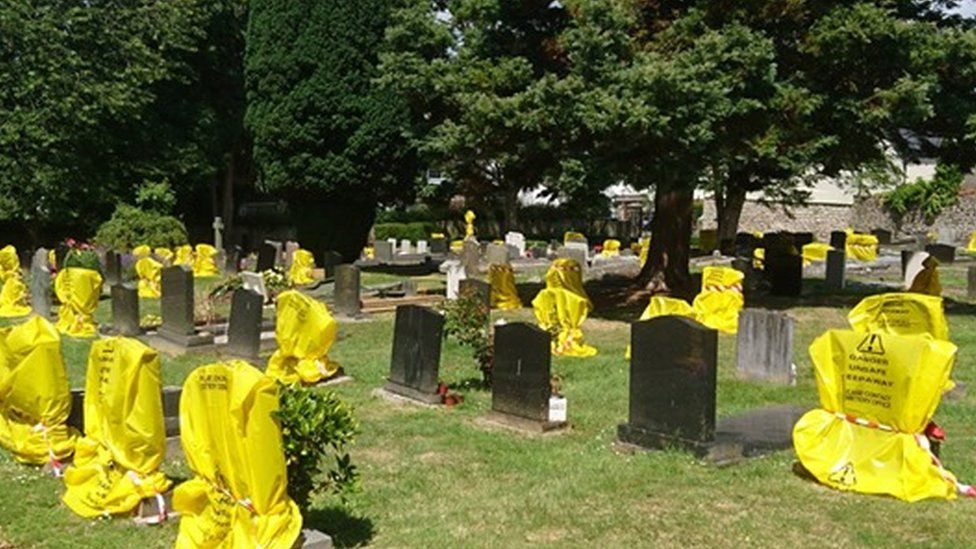 Headstones at the graveyard were covered in yellow plastic