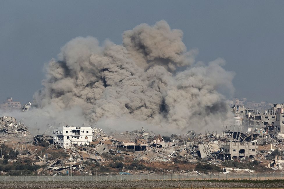 A picture taken from southern Israel near the border with the Gaza Strip on December 9, 2023, shows smoke rising above buildings during an Israeli strike in Gaza, amid continuing battles between Israel and the militant group Hamas.