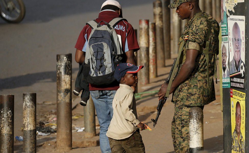 A boy looks at an Ugandan soldier in Kampala, Uganda - Saturday 20 February 2016
