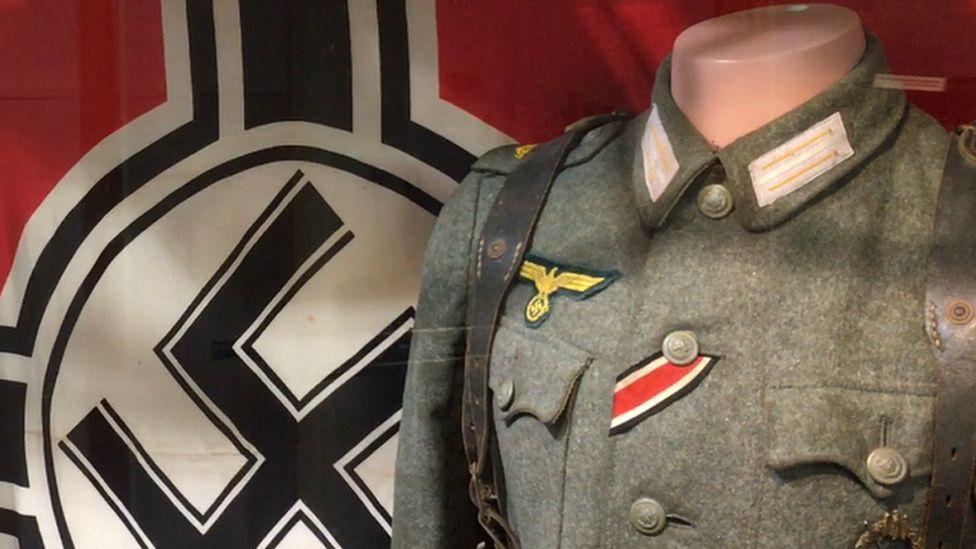 A Nazi swastika flag and uniforms on display in the Alderney Museum