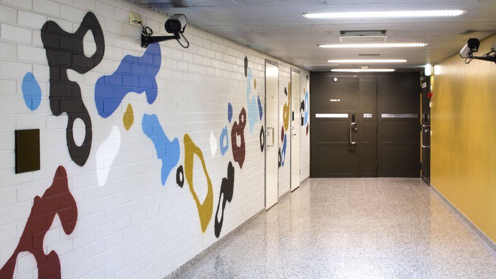 A corridor inside the prison with the EGS mural on one wall
