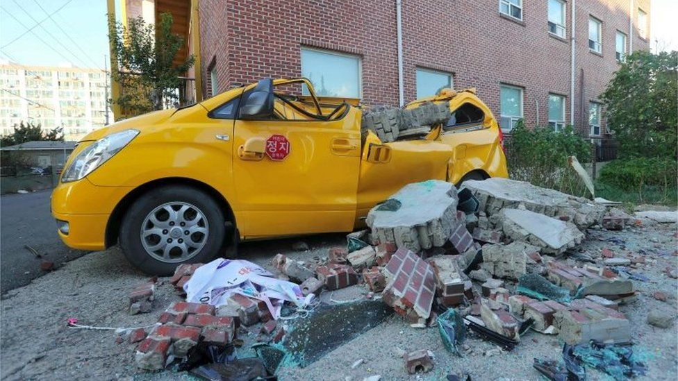 A car damaged by falling bricks after a 5.4-magnitude earthquake is seen in the southeastern port city of Pohang on November 15, 2017.