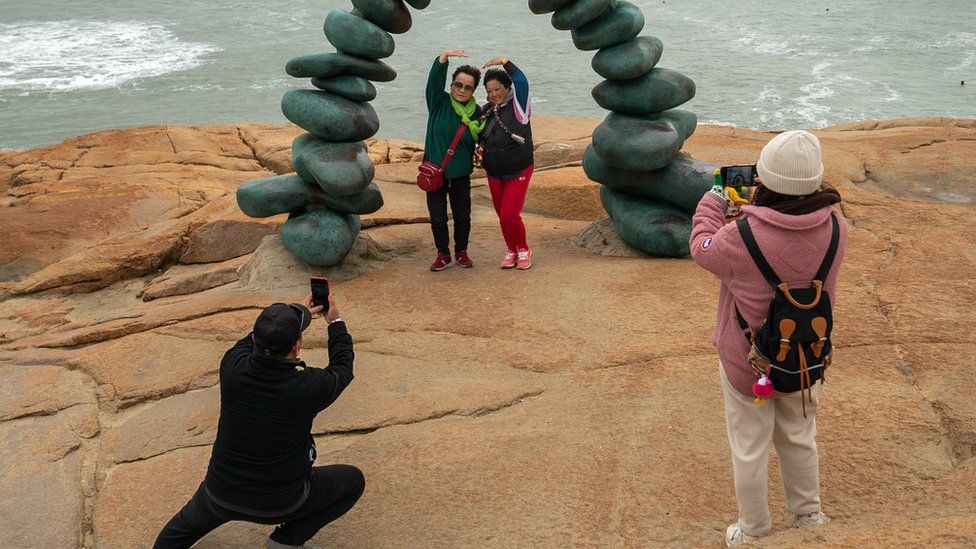 Tourists pose for a photograph