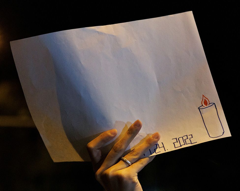 Protester holds up white sheet of paper