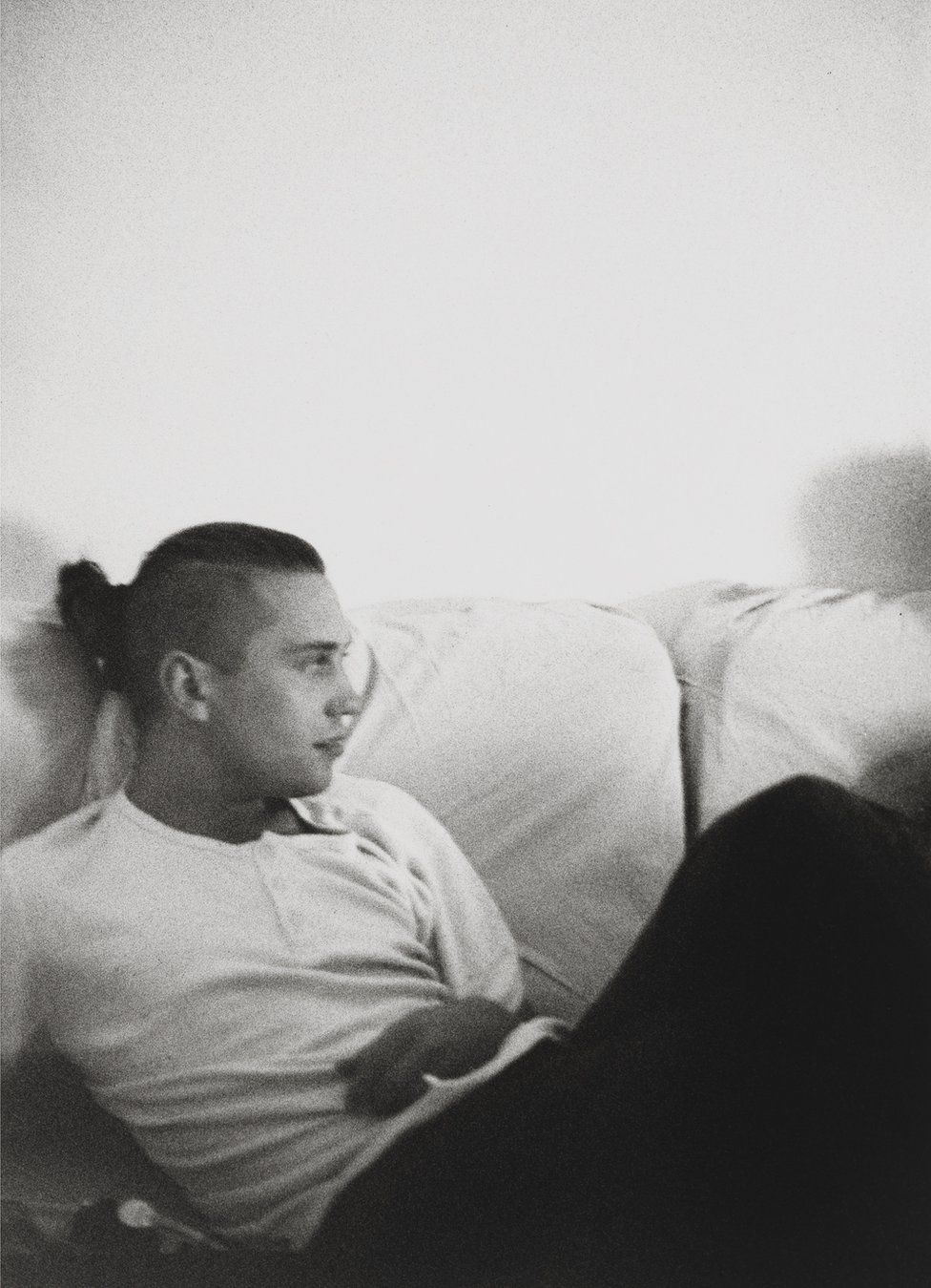 David Holah sits on a sofa in Bloomsbury, c.1984