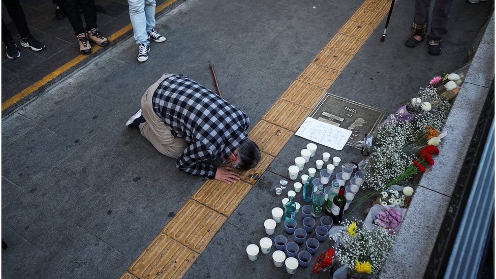 Человек отдает дань уважения возле места давки во время празднования Хэллоуина в Сеуле