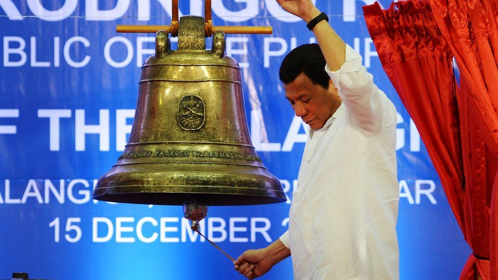 President Rodrigo Duterte rings one of the three Balangiga bells at a ceremony