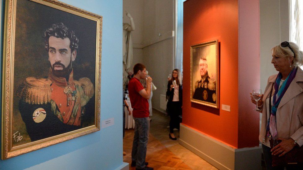 A portrait of Egyptian football player Mohamed Salah (L) is on display as visitors attend the opening of the Art Project "Like the Gods", presented by the Museum of the Russian Academy of Arts and Italian artist Fabrizio Birimbelli during the Russia 2018 World Cup in Saint Petersburg, on June, 20, 2018