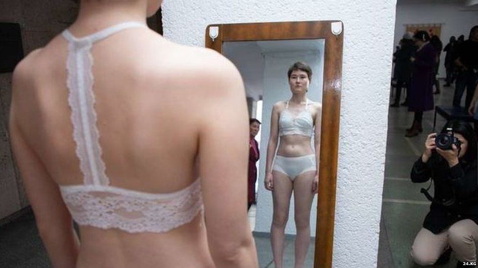 Woman in underware looking in a mirror