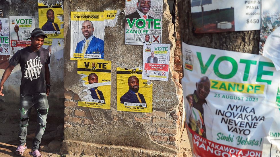 A man walks past election campaign posters in Macheke, Zimbabwe, 22 August 2023