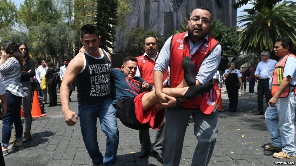 A rescued person is carried by two other people