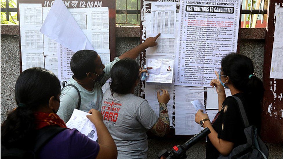 Students wearing face masks are seen checking for their enrolment numbers with their admission cards in hand at the examination centre before taking UPSC civil services prelims 2020.