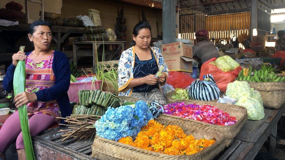 traders are seen sorting food in a quiet market area