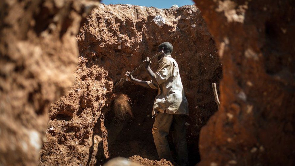 This photo taken on 31 May 2015 between Lubumbashi and Kolwezi, shows a man digging through some mine waste, searching for left over cobalt.