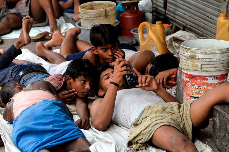 Indian labourers watch a movie on a mobile phone in the old quarters of New Delhi on July 14, 2019.