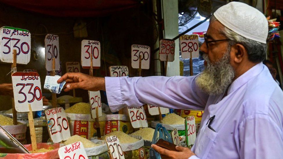 A customer pays for rice at a shop in Karachi, Pakistan.