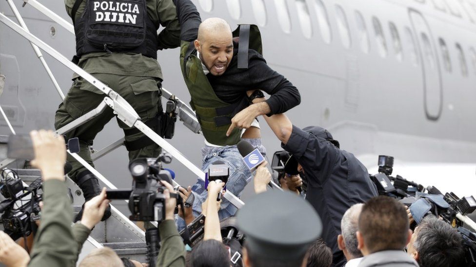 Alleged Peruvian drug trafficker Gerson Galvez shouts at the press as he is escorted by police officers into a Peruvian Air Force plane