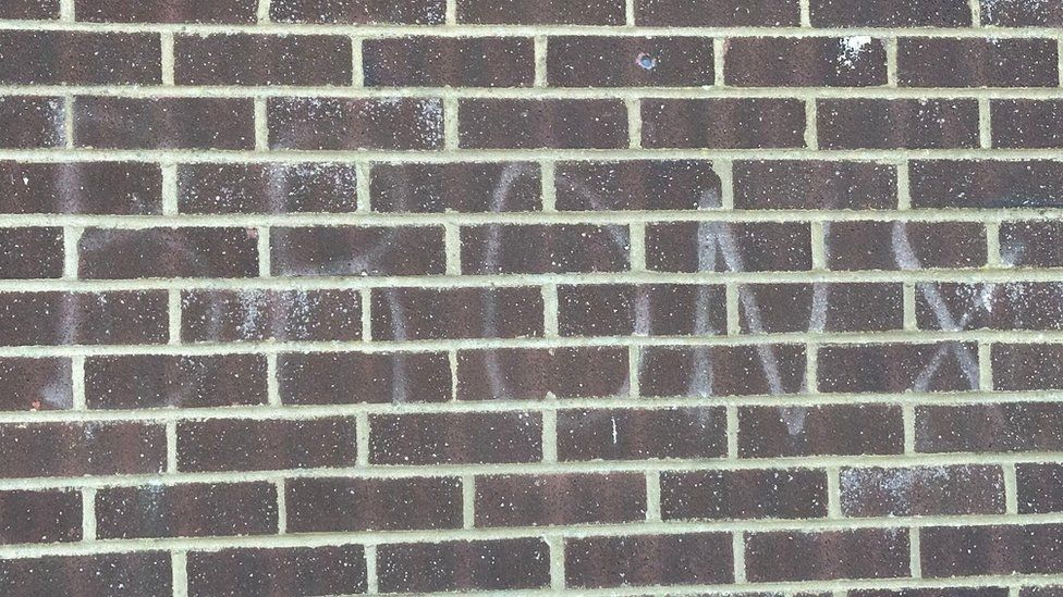 Faint outline of the word "Bronx" on a brick wall