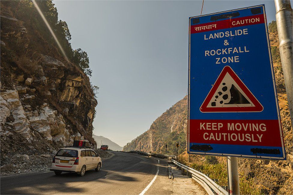 Предупреждающий знак для зоны оползней и камнепадов, размещенный вдоль дороги в Джошимате в районе Чамоли, Уттаракханд, Индия, в среду, 9 февраля 2022 г.