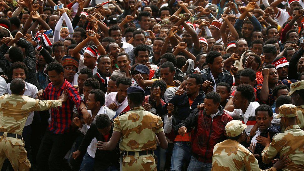 Demonstrators chant slogans while flashing the Oromo protest gesture during Irreecha in Ethiopia - 5 October 2016