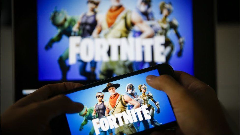 A man plays Fortnite game on smartphone
