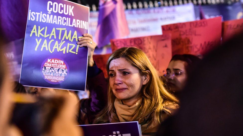 A woman cries next to another holding a sign reading "We will not forgive child rapists" during a demonstration against a proposed bill in Istanbul on November 18, 2016