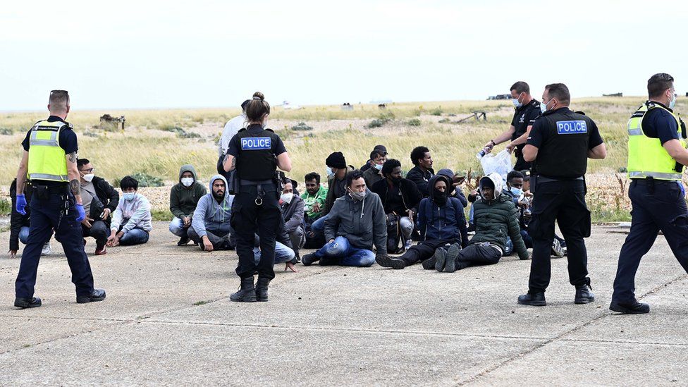 Migrants waiting with police