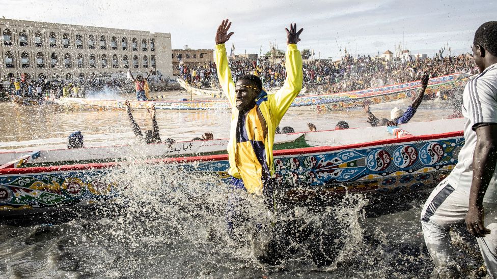 Supporters cheer as their teams pirogue is unveiled in the fishing village of Guet N'Dar in Saint-Louis in Senegal - Saturday 23 July 2022