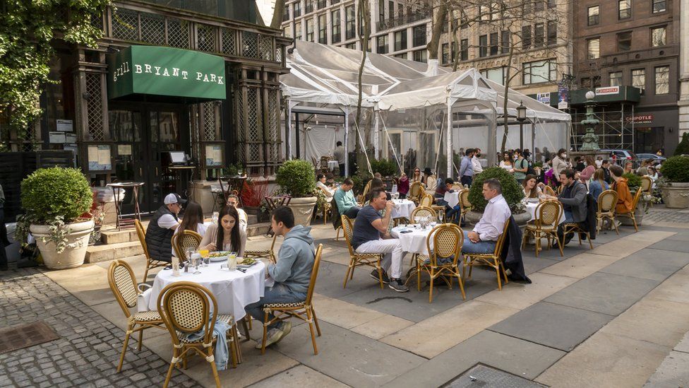 People eat outside at a restaurant in Bryant Park, New York