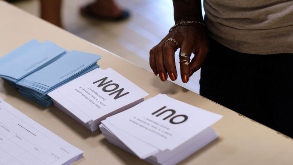 A voter looks at ballot papers in New Caledonia
