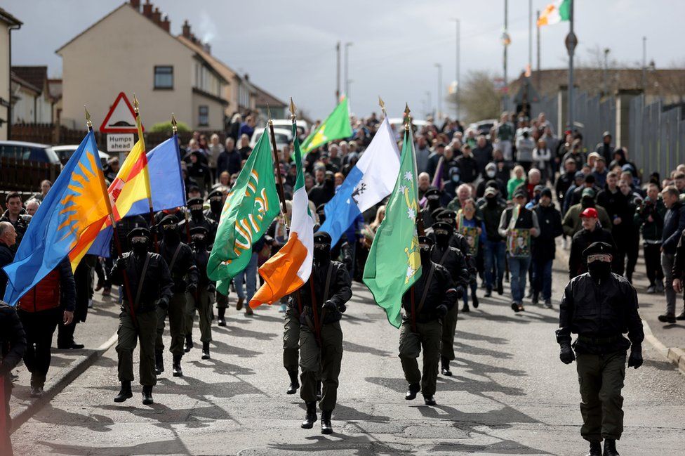 People in paramilitary-style clothing march in a republican parade in Londonderry
