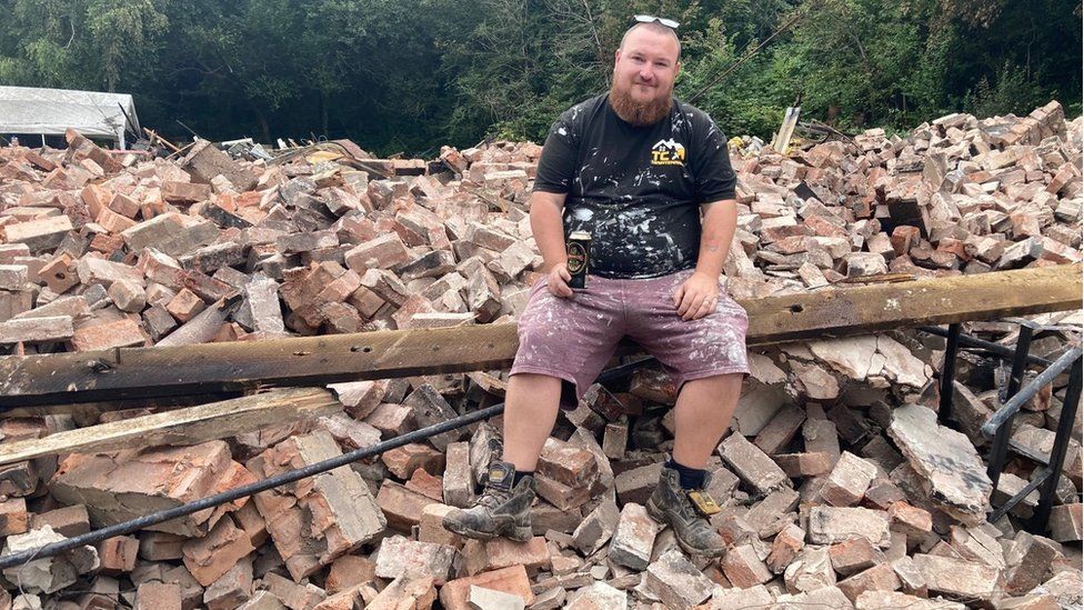 Former landlord Tom Catton having a last drink in the rubble