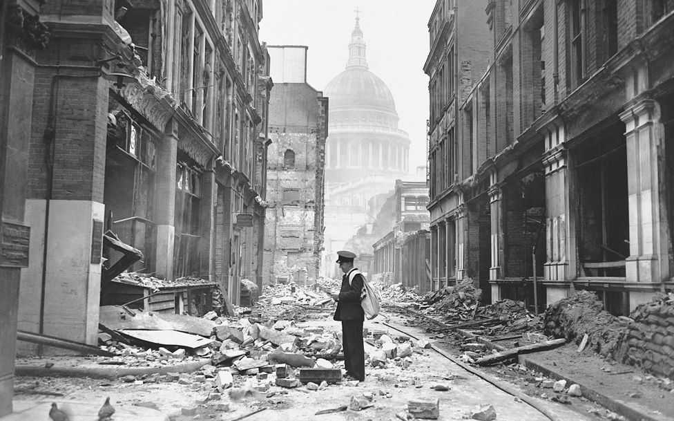 Почтальон пытается доставить письма на разрушенной бомбой улице возле собора Павла в конце лондонской молниеносной войны, май 1941 г.