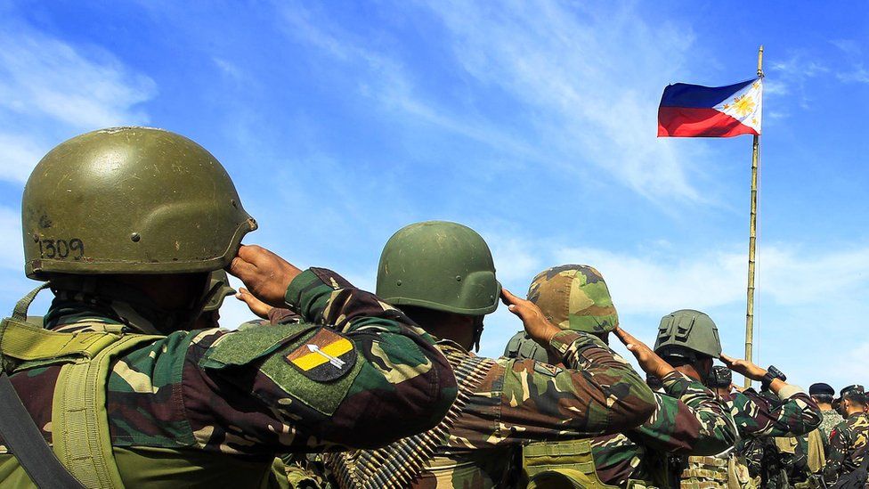 Philippine soldiers salute during a flag ceremony as they end their operation against Islamic militants in Butig Town, Lanao Del Sur on the southern Philippine island of Mindanao on March 1, 2016.