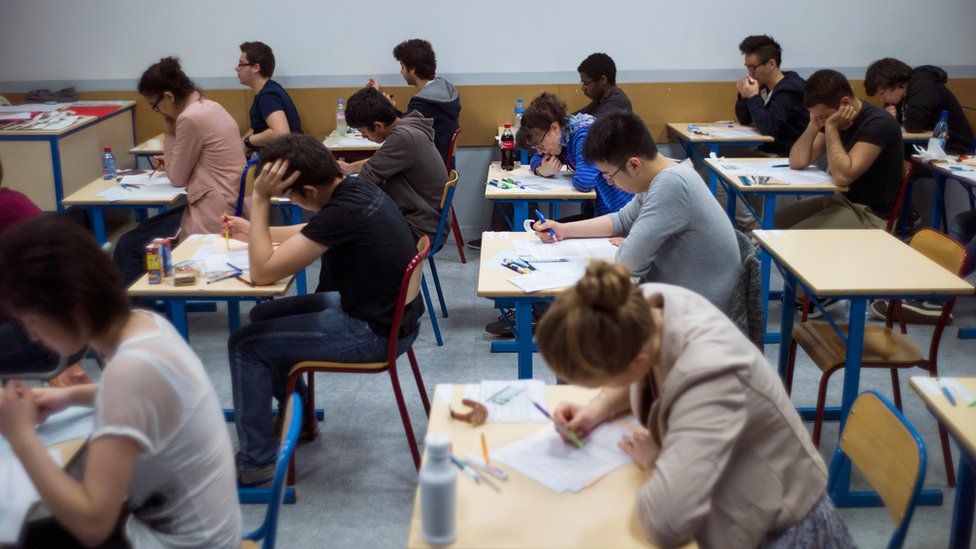 French students work on the test of philosophy as they take the baccalaureat exam (high school graduation exam) on June 17, 2013 at the Arago high school in Paris