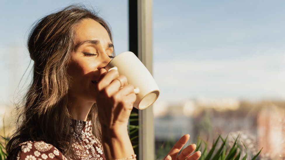 A woman drinking a mug of tea