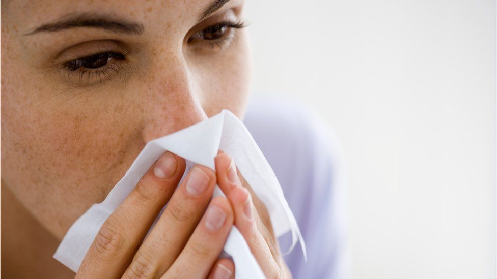 Woman blowing nose