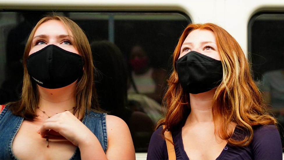 Two women in face masks on Tube train