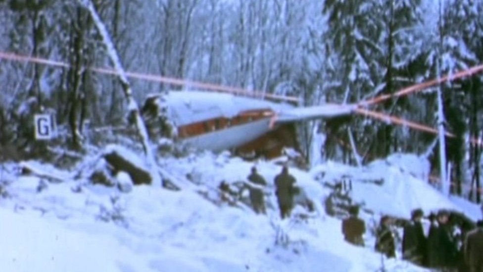 Scene of plane crash in Basel showing wreckage among trees and snow