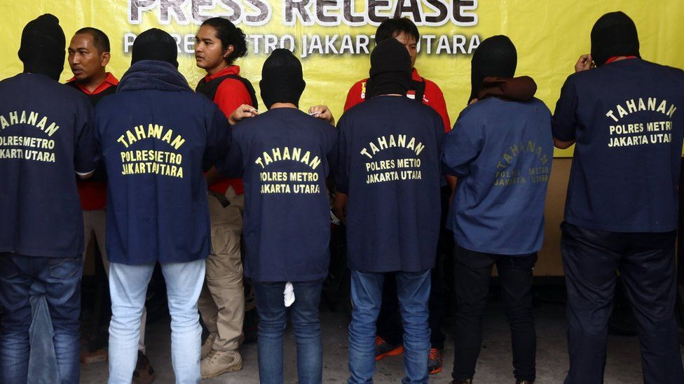 Indonesian police officers stand guard as men arrested in a raid are shown to the media during a news conference at a police station in Jakarta, Indonesia, 22 May 2017
