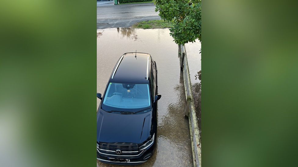 Car on a flooded driveway