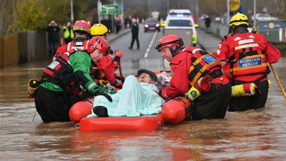 Rescuers help Peter Morgan in a boat