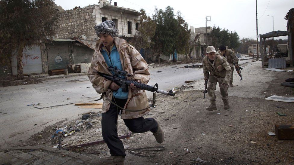 Syrian Turkmen rebels run across a street controlled by regime forces to dodge sniper fire in the Hanano district of the northern city of Aleppo in 2013
