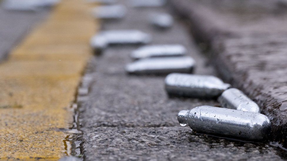 Empty canisters of nitrous oxide littering a street