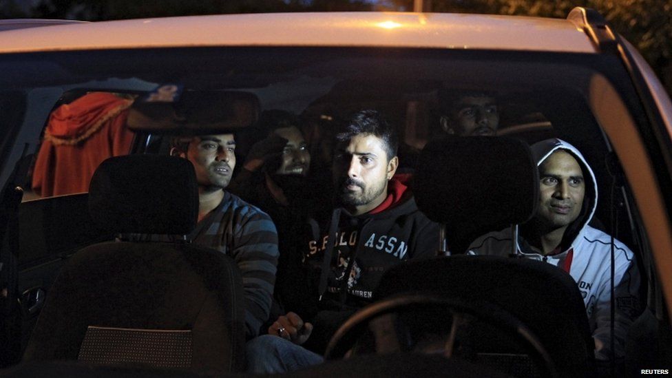 Migrants sit in a car, on their way through Austria