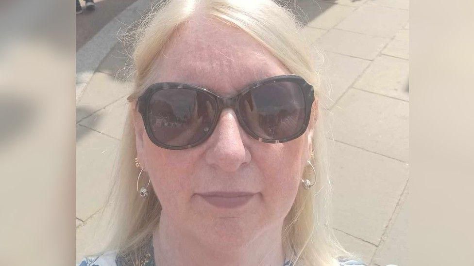 A selfie of Alison Moss, a blonde-haired woman wearing sunglasses
