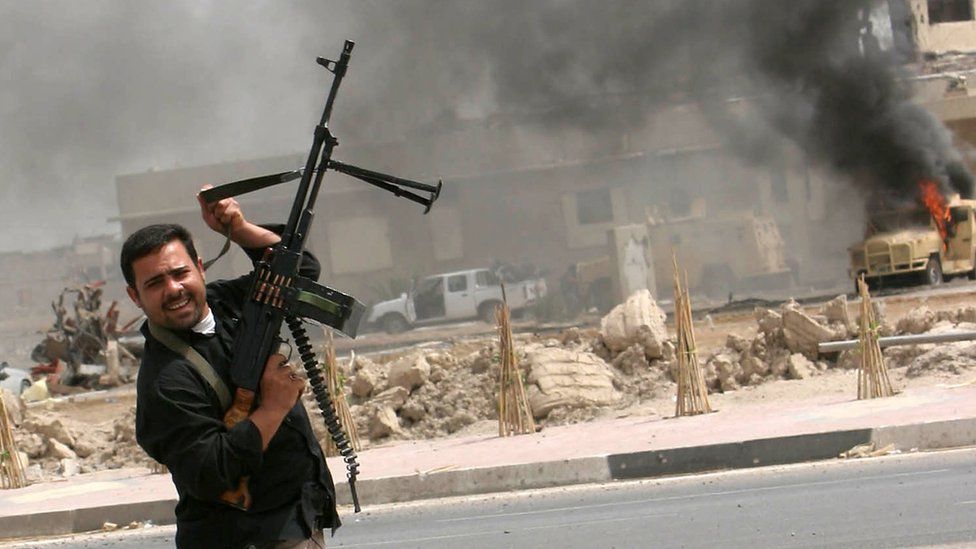 Mehdi Army militiaman fires machine-gun into the air during fighting in the Iraqi city of Basra on 30 March 2008