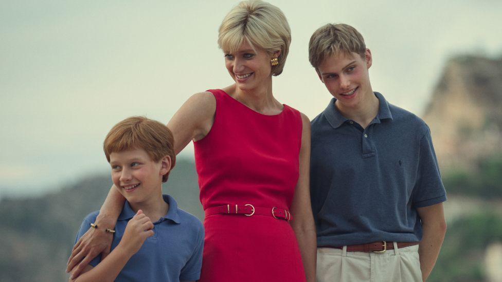 Production still image of Elizabeth Debicki as Princess Diana with Fflyn Edwards as young Prince Harry (l) and Rufus Kampa as young Prince William (r) in the final season of The Crown