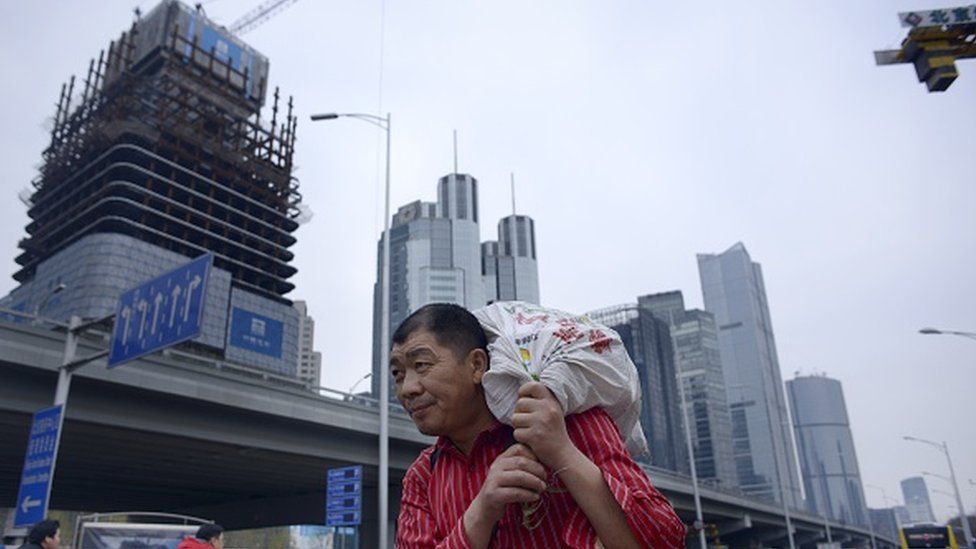 A man carrying a package as he walks through Beijing