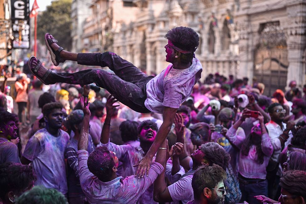 Revellers stained with coloured powder cheer during the Holi festival celebrations in Chennai